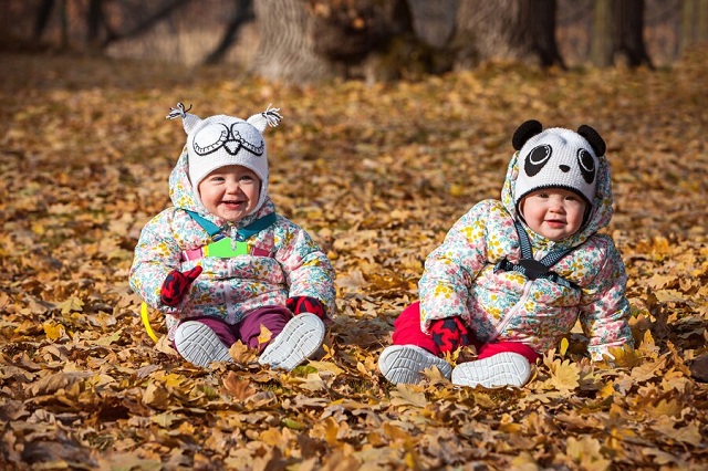 deux petites filles assises dans les feuilles d'automne